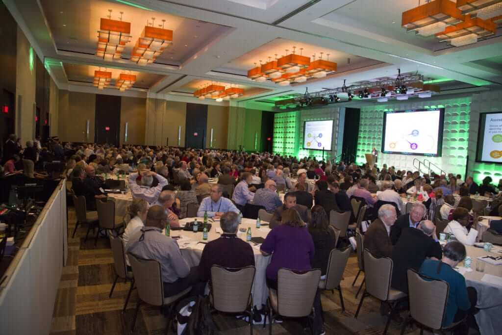 Britt speaks to an audience at a large conference.